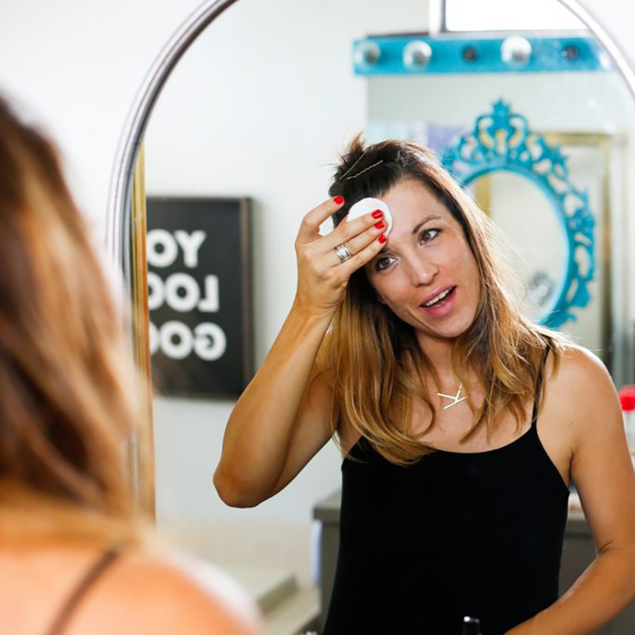 woman using cotton round on face